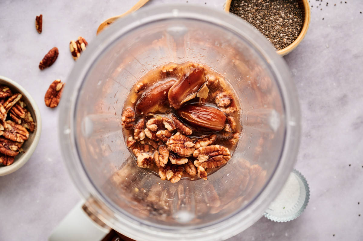 Dates and pecans with water in a blender.
