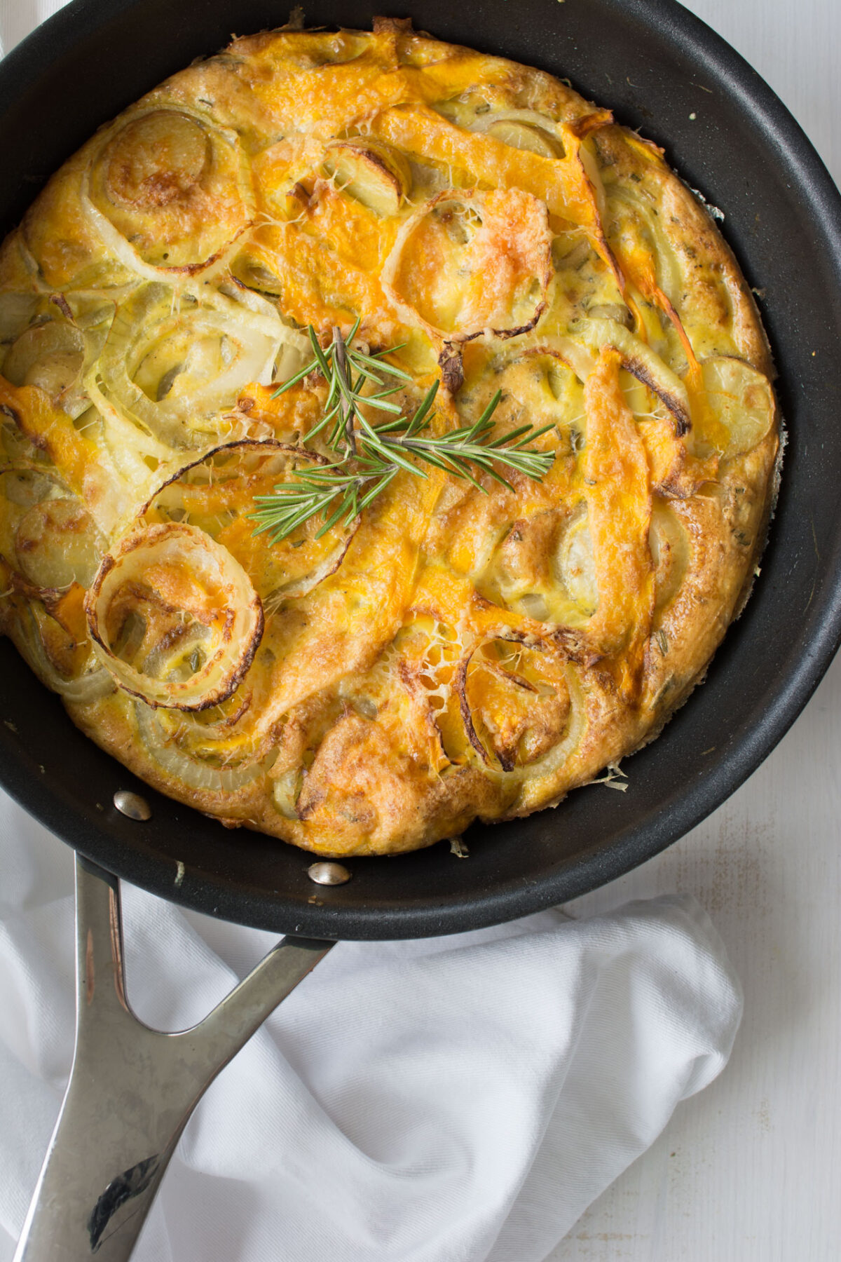 top down view image of a freshly baked Butternut Squash Frittata in a wok, topped with fragrant rosemary