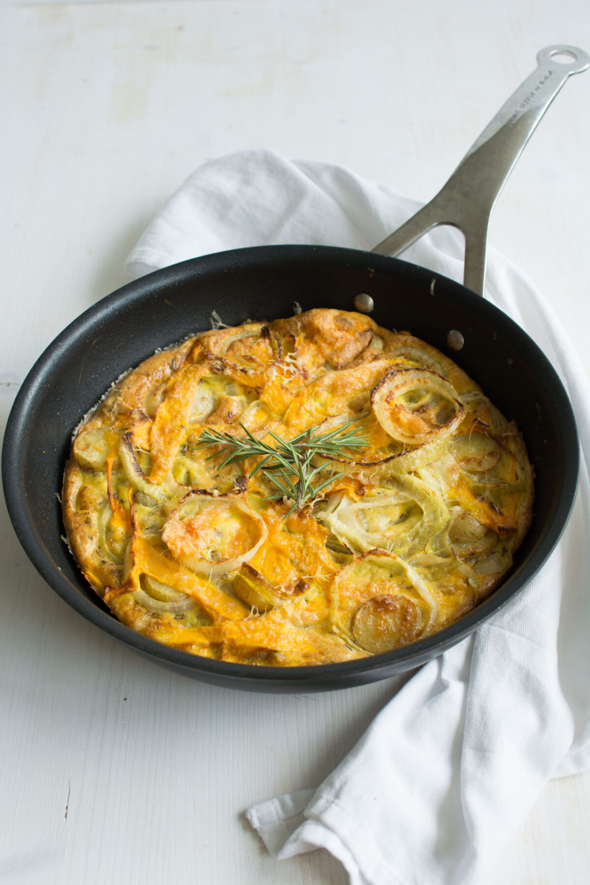 close-up top view of a freshly baked Butternut Squash Frittata in a wok, topped with fragrant rosemary