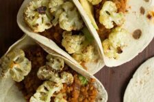 tacos filled with roasted cauliflower, spicy lentils, sultanas and avocado