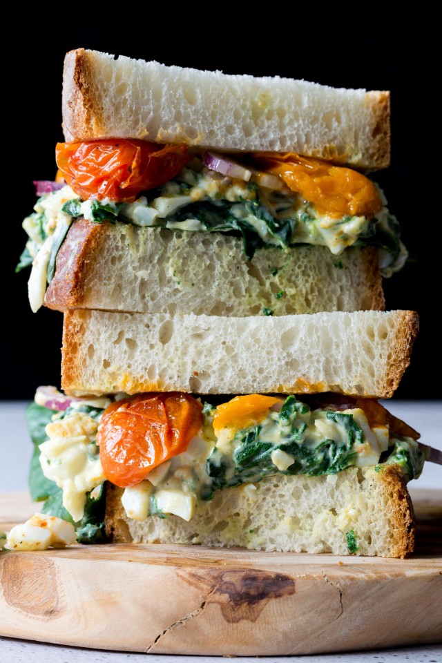 close up image of a delicious egg florentine sandwich with roasted tomatoes