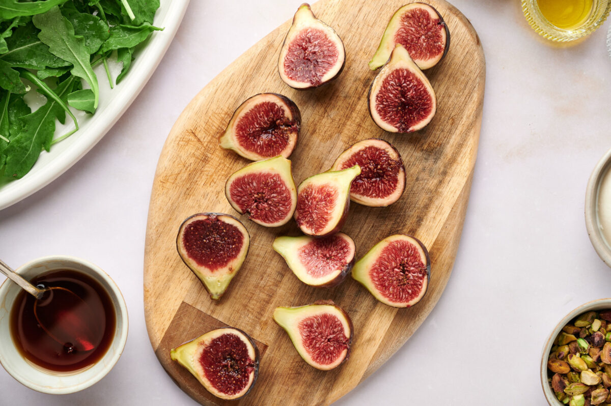 Figs sliced in half on a cutting board.