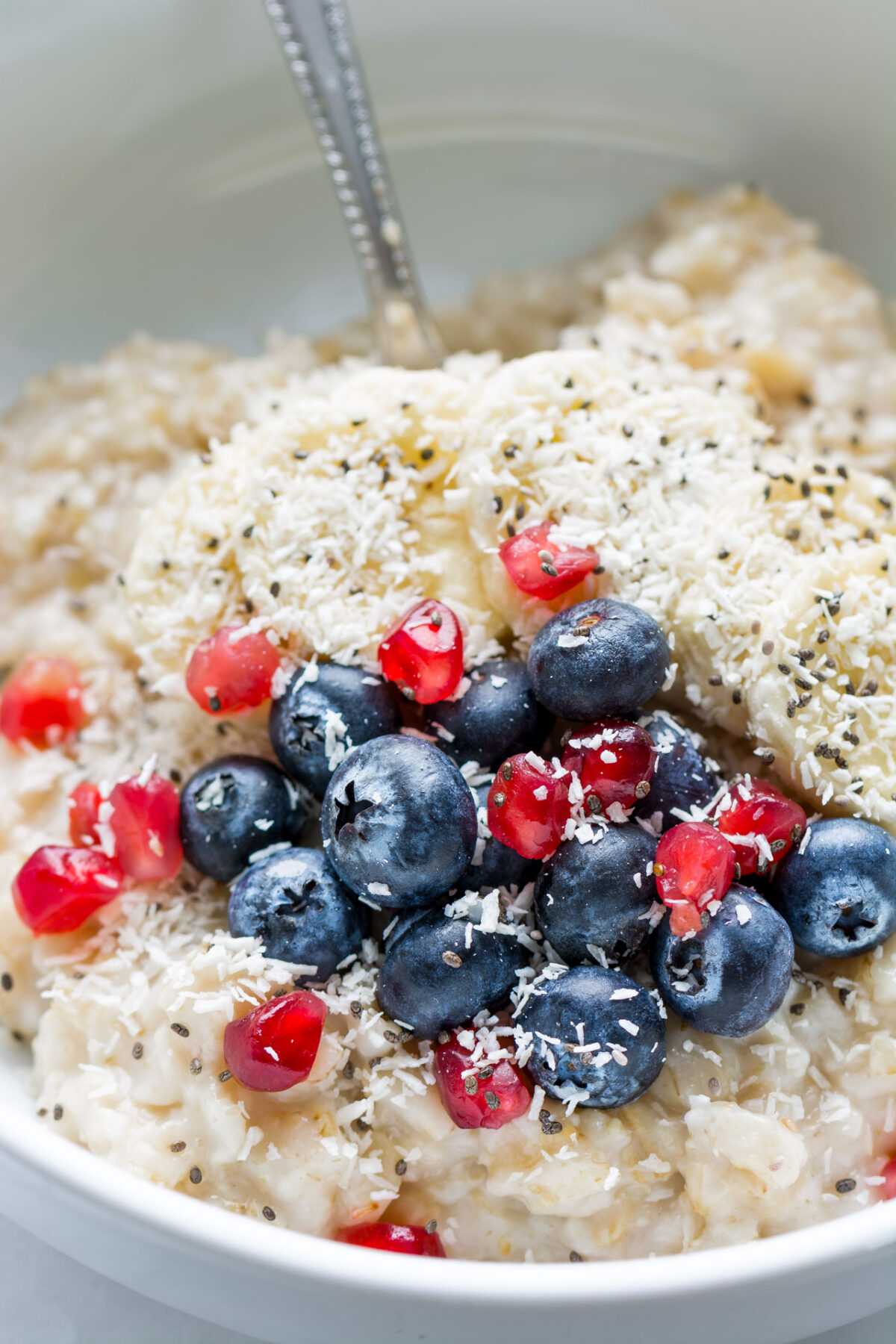 close up image of an oatmeal topped with shredded coconut and mixed berries