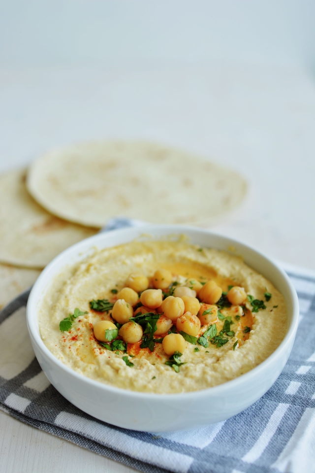 freshly cooked hummus in a bowl topped with cooked chickpeas