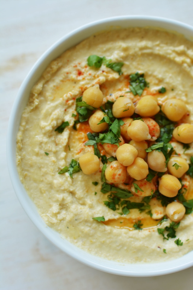 top view image of a freshly cooked hummus with cooked chickpeas on top