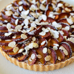close up image of a freshly baked plum and almond tart