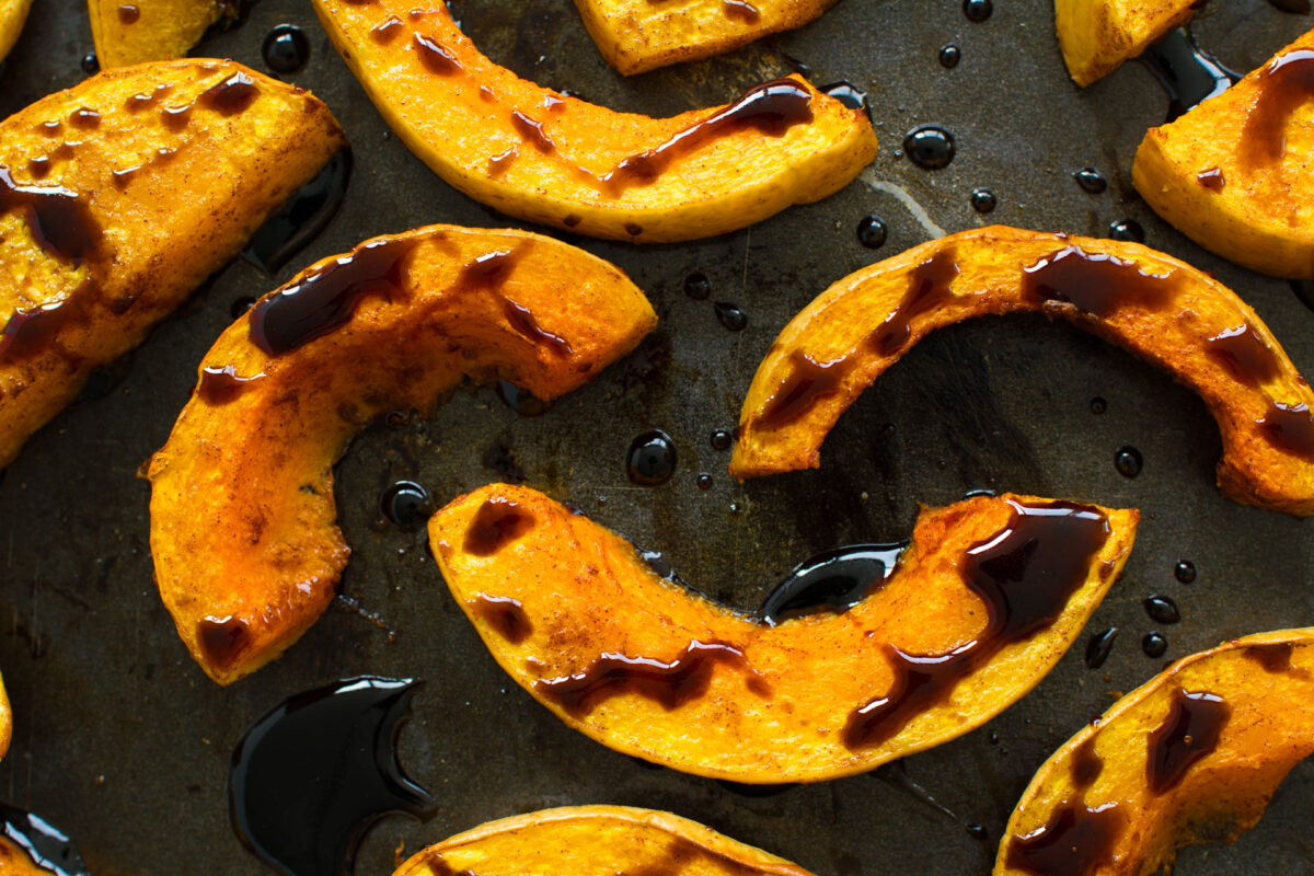 close up image of sliced roasted butternut squash drizzled with balsamic glaze 