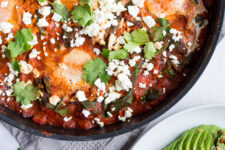 Shakshuka with Spinach in a wok topped with feta cheese.