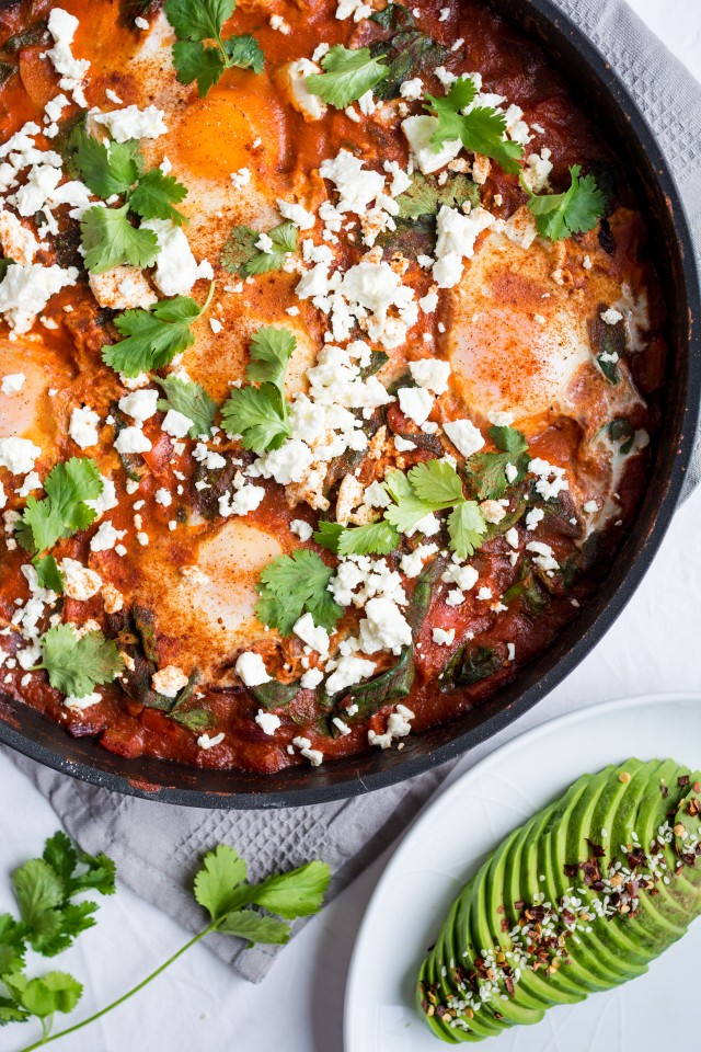 Shakshuka with Spinach  in a wok topped with feta cheese. 
