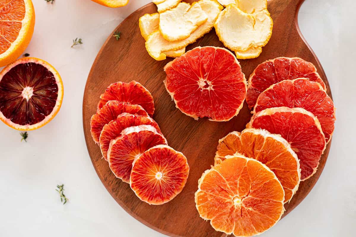 Blood oranges, Cara Cara oranges, and pink grapefruit slices peeled and arranged on a cutting board.