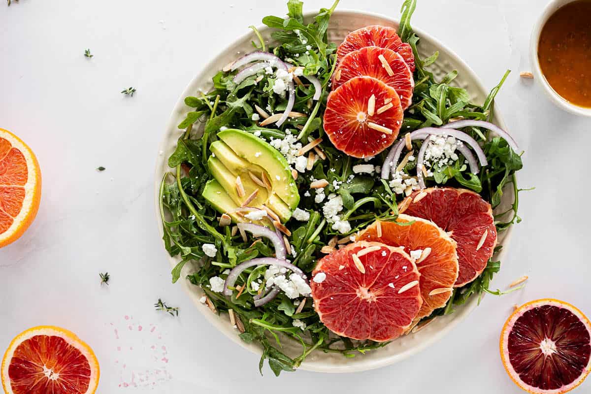 Winter Citrus Salad with blood oranges, cara cara oranges, and grapefruit, topped with cheese, toasted almonds, avocado, and onions.