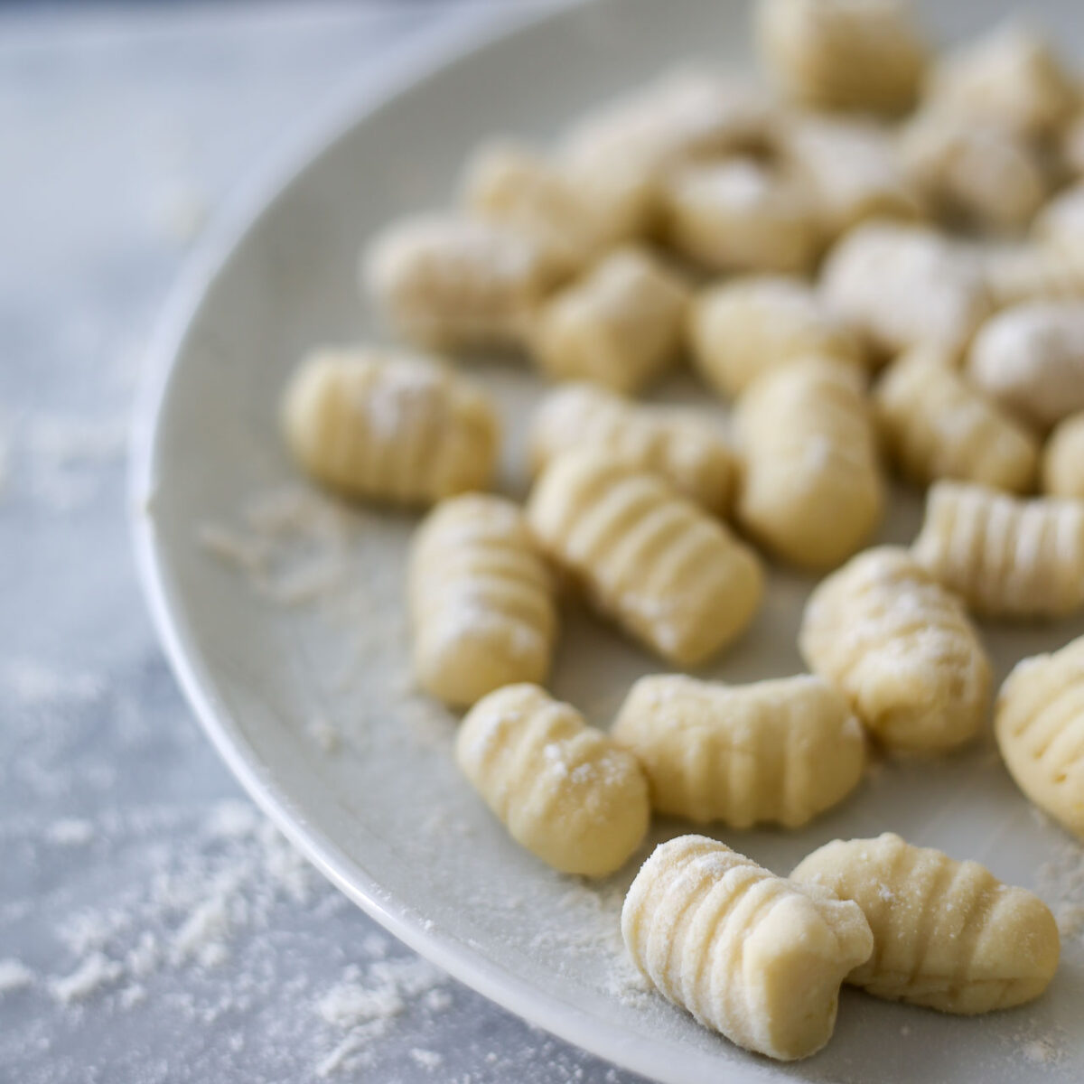 A plate filled with uncooked gnocchi.